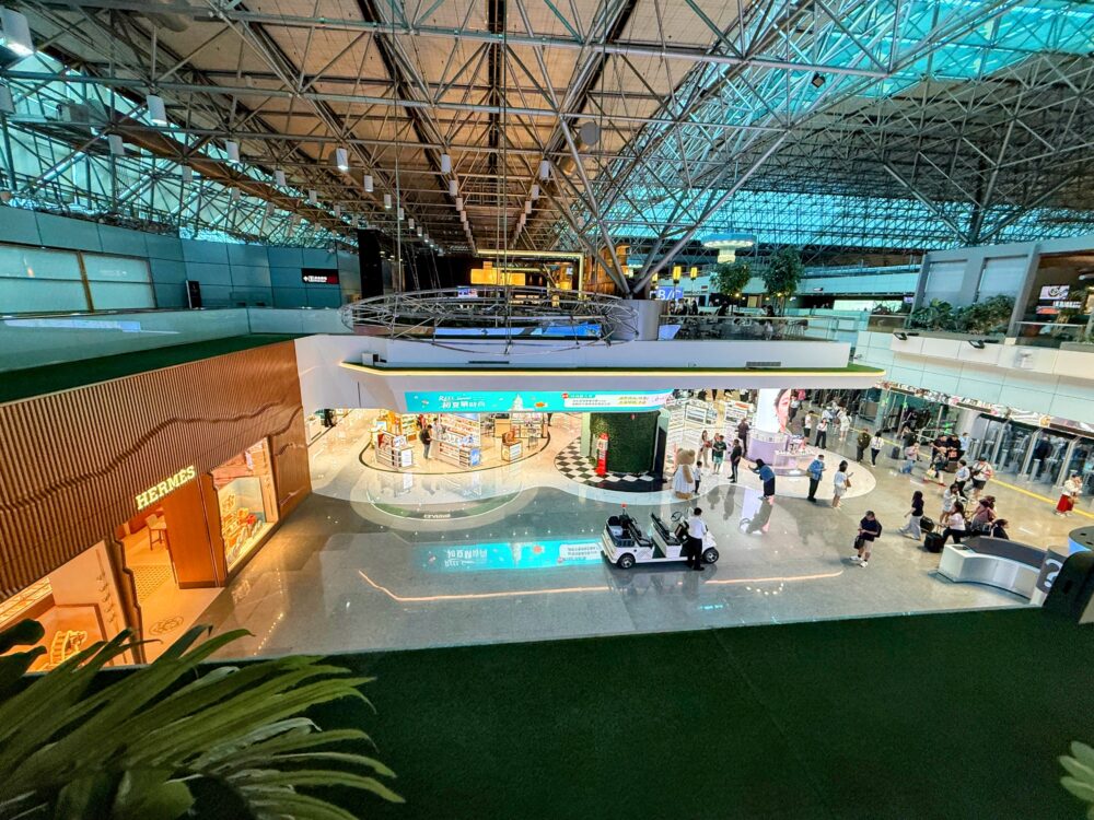 桃園国際空港の広大なターミナル内にあるエルメスなどの免税店ショッピングエリアを上から見渡した様子