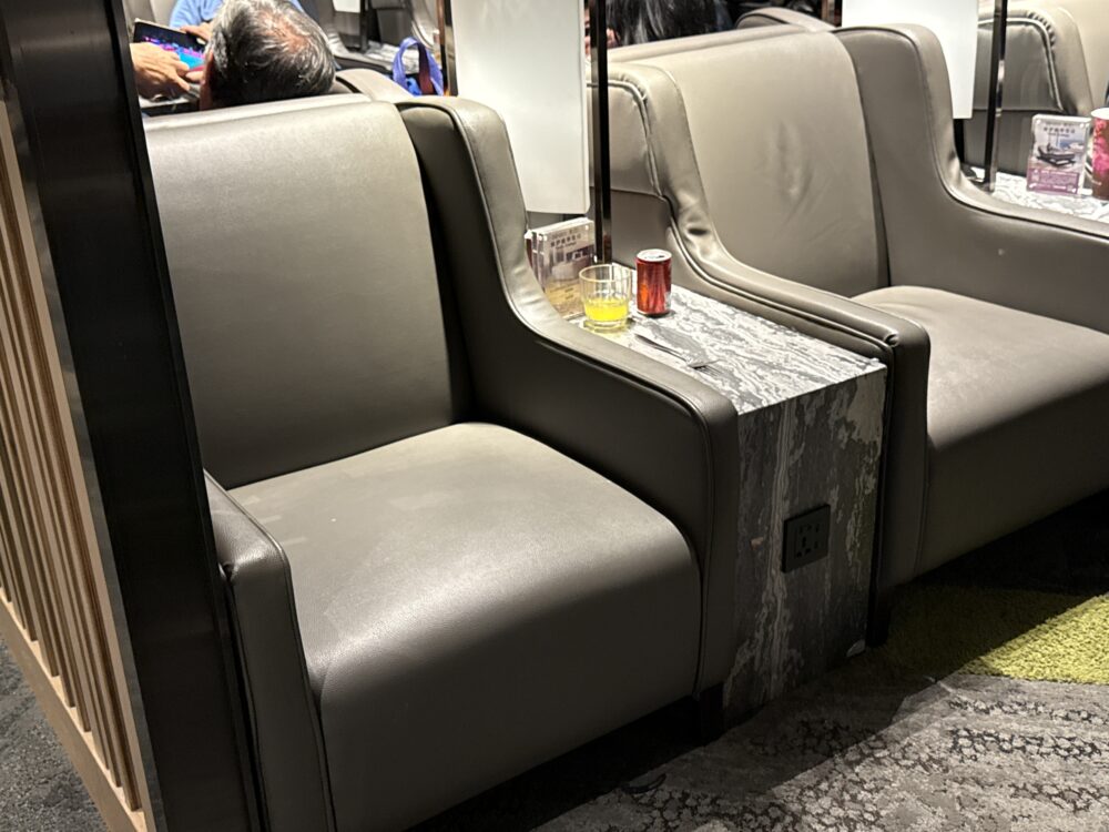 桃園国際空港プライオリティパス対応ラウンジの落ち着いたグレーのソファ席と大理石調サイドテーブル