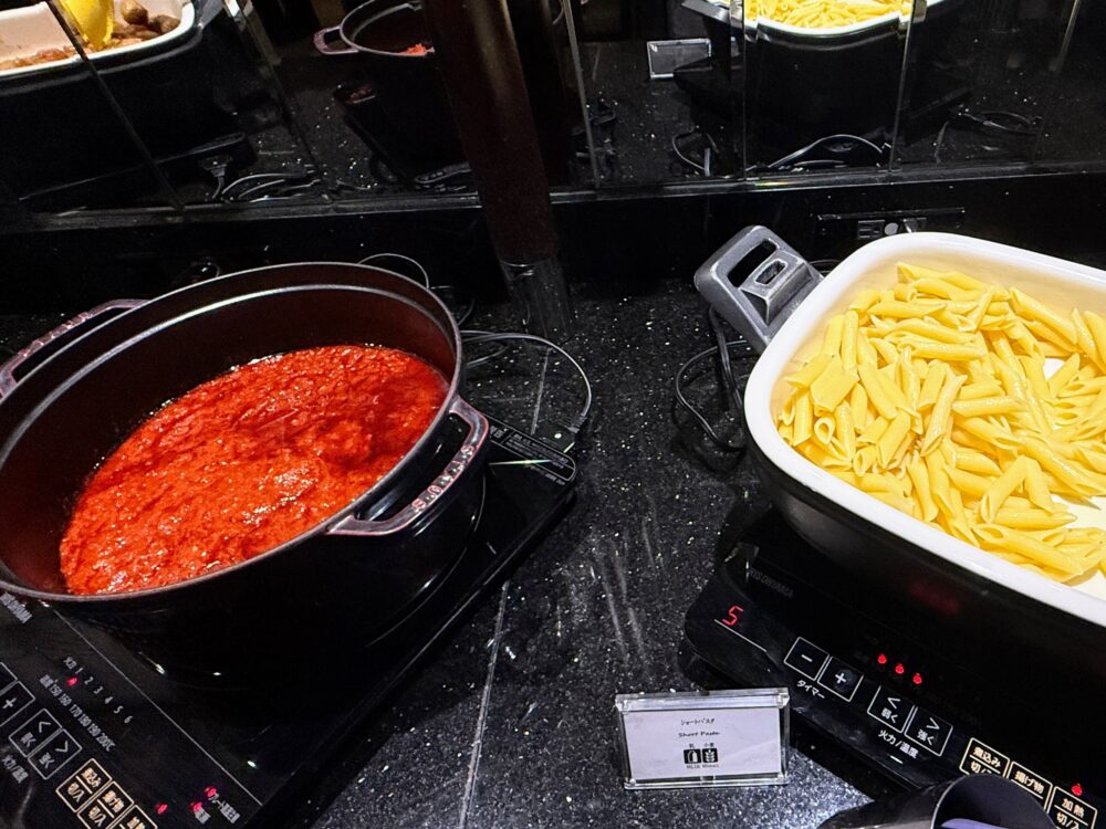 ラウンジの夕食代わりにもなるホットミール。ショートパスタ（ペンネ）とトマトソースのポット。