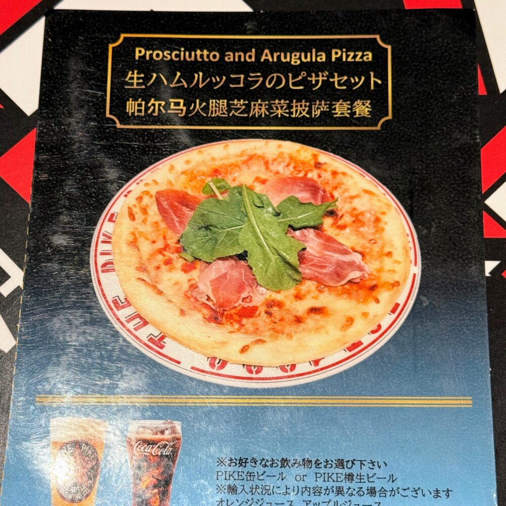プライオリティパス専用セットメニュー「生ハムルッコラのピザセット(Prosciutto and Arugula Pizza)」の案内カード。生ハムとルッコラをのせた薄焼きピザの写真。