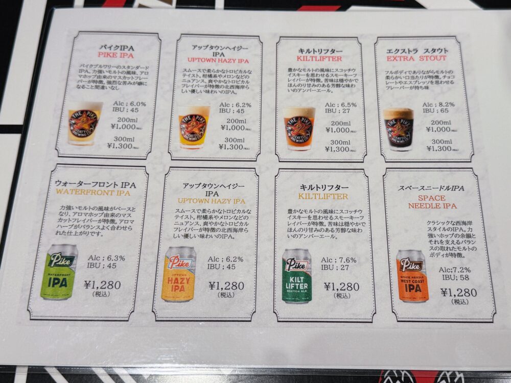 ザ・パイクブリューイングのクラフトビールメニュー一覧。上段は樽生ビール4種(パイクIPA・アップタウンヘイジーIPA・キルトリフター・エクストラスタウト、各200ml ¥1,000/300ml ¥1,300)、下段は缶ビール4種(ウォーターフロントIPA・アップタウンヘイジーIPA・キルトリフター・スペースニードルIPA、各¥1,280税込)が紹介されている。