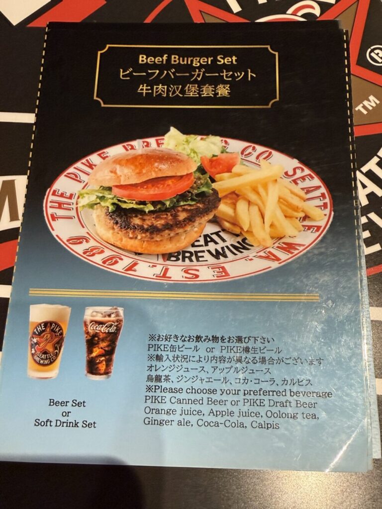 ザ・パイクブリューイングのビーフバーガーセットのメニュー表(セントレア店)、フライドポテト添えとドリンク選択肢が記載されている