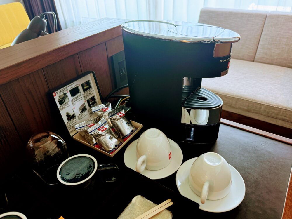 フォーポイントバイシェラトン名古屋中部国際空港のジュニアスイートに設置されたillyのコーヒーマシン。コーヒーカプセルとillyのカップが並んでいる。