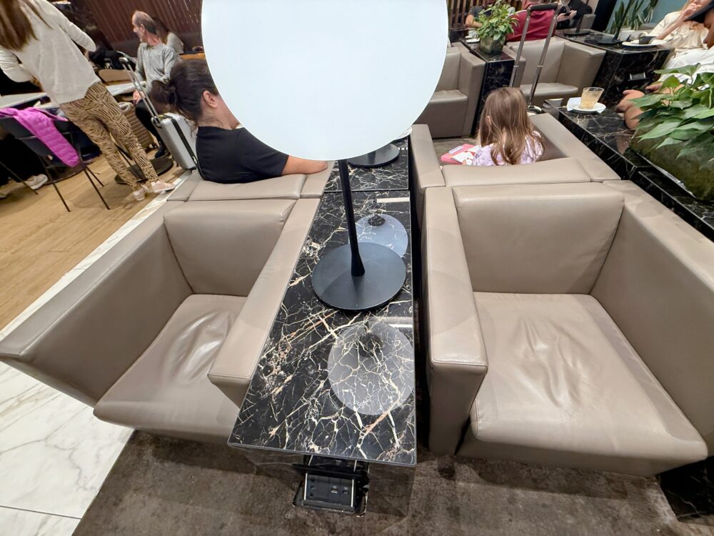 Plaza Premium Loungeのソファ席エリア。大理石調のテーブルを挟んで配置された落ち着いた色合いの座席。