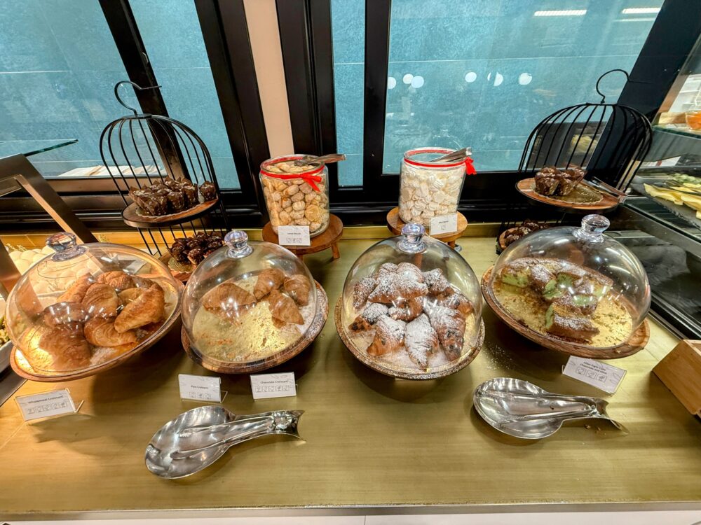 Plaza Premium Loungeの朝食。クロワッサンやケーキなどペストリーがガラスカバーに入って並んでいる。