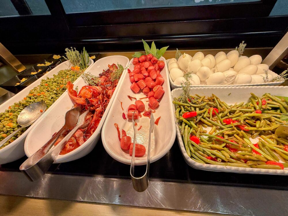 Plaza Premium Loungeの朝食。ベーコン、ソーセージ、ゆで卵、インゲンの炒め物などが並ぶ。