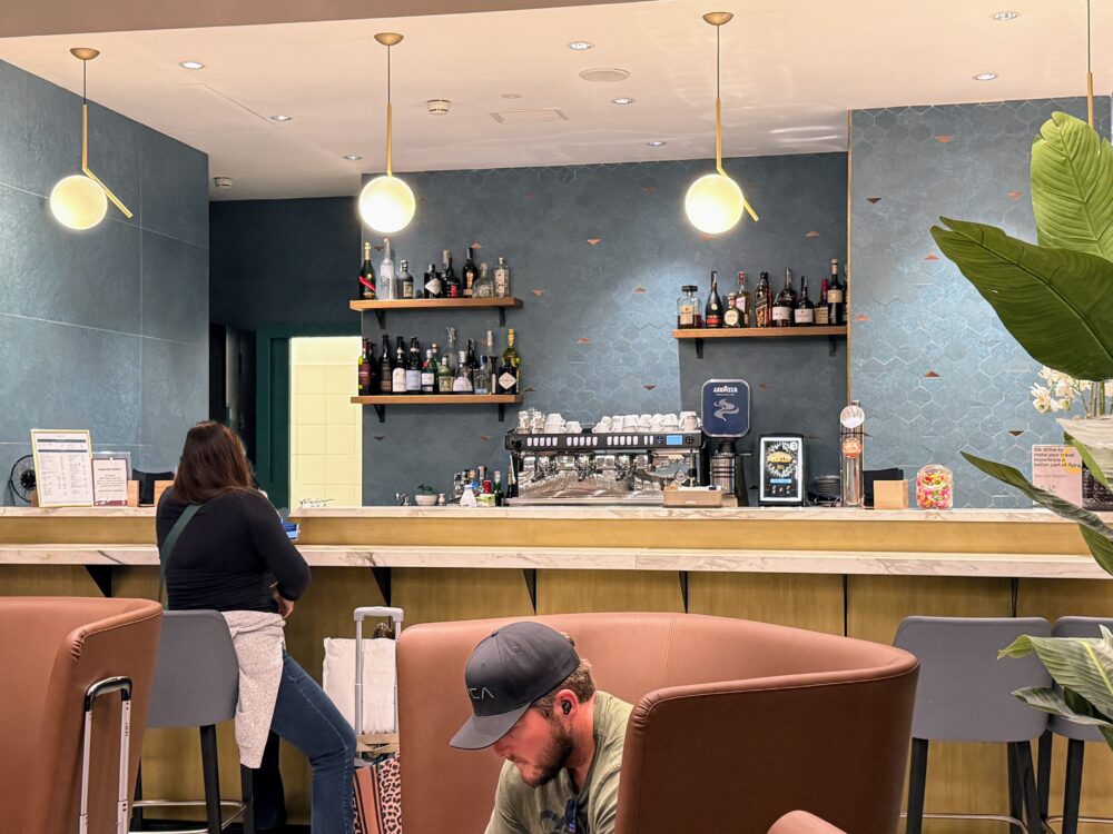 Plaza Premium Loungeのバーカウンター。青い壁面にボトルが並び、照明が明るくスタイリッシュな雰囲気。