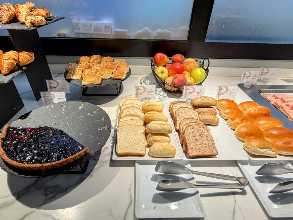 食パンやロールパン、バゲット、りんご、ケーキが並んでいる。