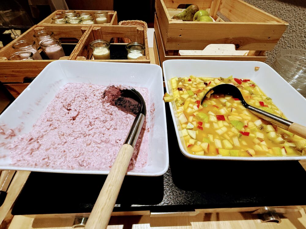 朝食ビュッフェのフルーツサラダとミューズリー。新鮮な果物と穀物を混ぜたスイス定番の朝食。