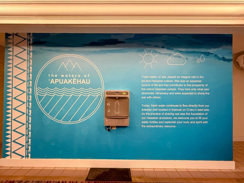 ホテル内に設置された給水ステーション『the waters of ʻApuakehau』。ハワイの水文化について説明が書かれた青い壁面と、ウォーターボトル用の給水機が映っている。