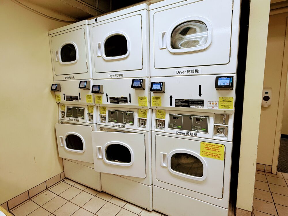 洗濯機がずらりと並ぶコインランドリーエリア。長期滞在や家族旅行に便利な設備。