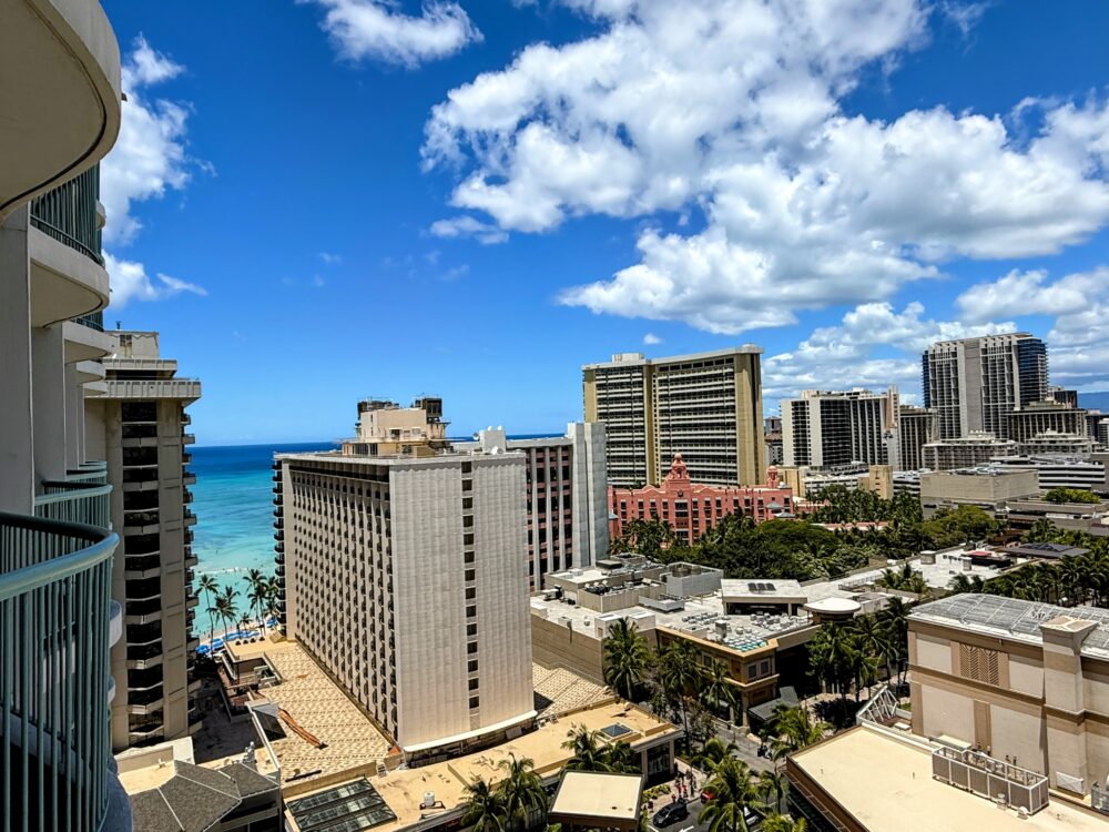 シェラトン・プリンセス・カイウラニの客室ラナイからの昼の景色。青い海と空、ワイキキのビル群が広がるパノラマビュー。