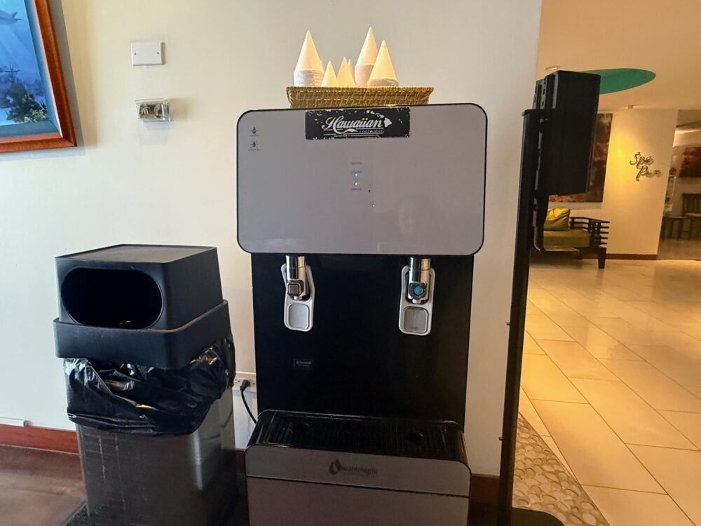 ホテルロビーの給水機（ウォーターサーバー）。ハワイアンのロゴと紙コップ。