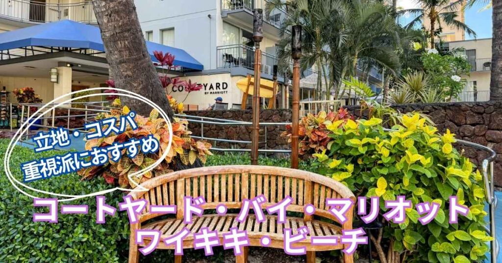 コートヤード・バイ・マリオット・ワイキキ・ビーチの外観。南国の植物と木製ベンチが並ぶ中庭前には、ホテルの看板と青い屋根のエントランスが見える。『立地・コスパ重視派におすすめ』の文字入りアイキャッチ画像。