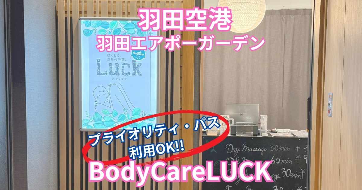 羽田空港直結の羽田エアポートガーデン2階にあるマッサージ店「Body Care LUCK」の入口。店頭看板に「プライオリティ・パス利用OK」と表示されており、木目の壁と受付カウンターが見える。