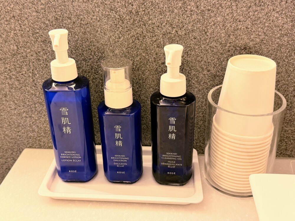 シャワールームの洗面台に用意されている雪肌精のスキンケアセット(クレンジング、化粧水、乳液)。