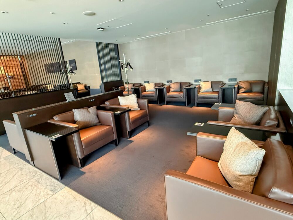ANAスイートラウンジの奥にある、複数の茶色い一人掛けソファがゆったりと配置された落ち着いたエリア。