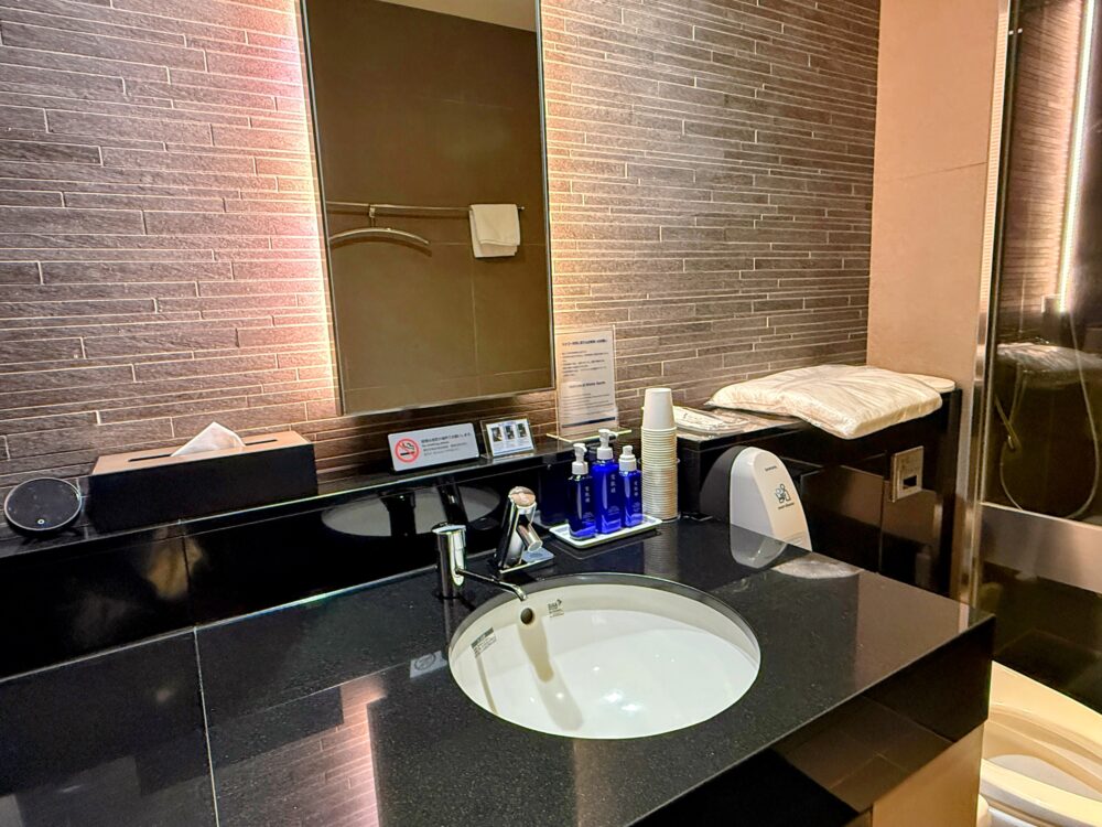 雪肌精のアメニティが並ぶANAスイートラウンジのシャワールーム洗面台