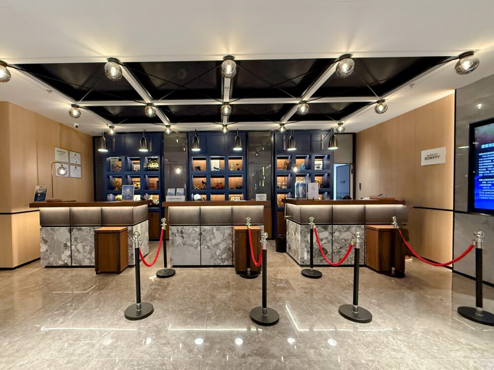 フォーポイント バイ シェラトン 北京三里屯ワーカーズスタジアムのフロントデスク。大理石調のカウンターと温かみのある照明が上品で落ち着いた雰囲気を演出している。