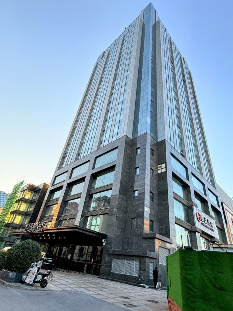 フォーポイント バイ シェラトン 北京三里屯ワーカーズスタジアムの外観。ガラス張りの高層ビルで、モダンかつスタイリッシュな印象の新しいマリオット系列ホテル。