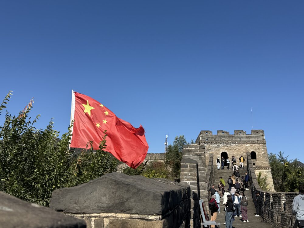 慕田峪長城の見張り台横にはためく中国国旗。青空と石造りの長城が対照的な印象的な一枚。