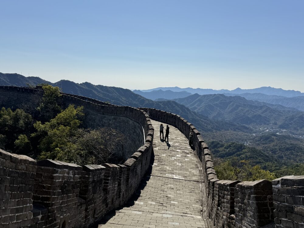 慕田峪長城の曲線が美しい石畳の通路。奥に連なる見張り台と山々が見える絶景ポイント。
