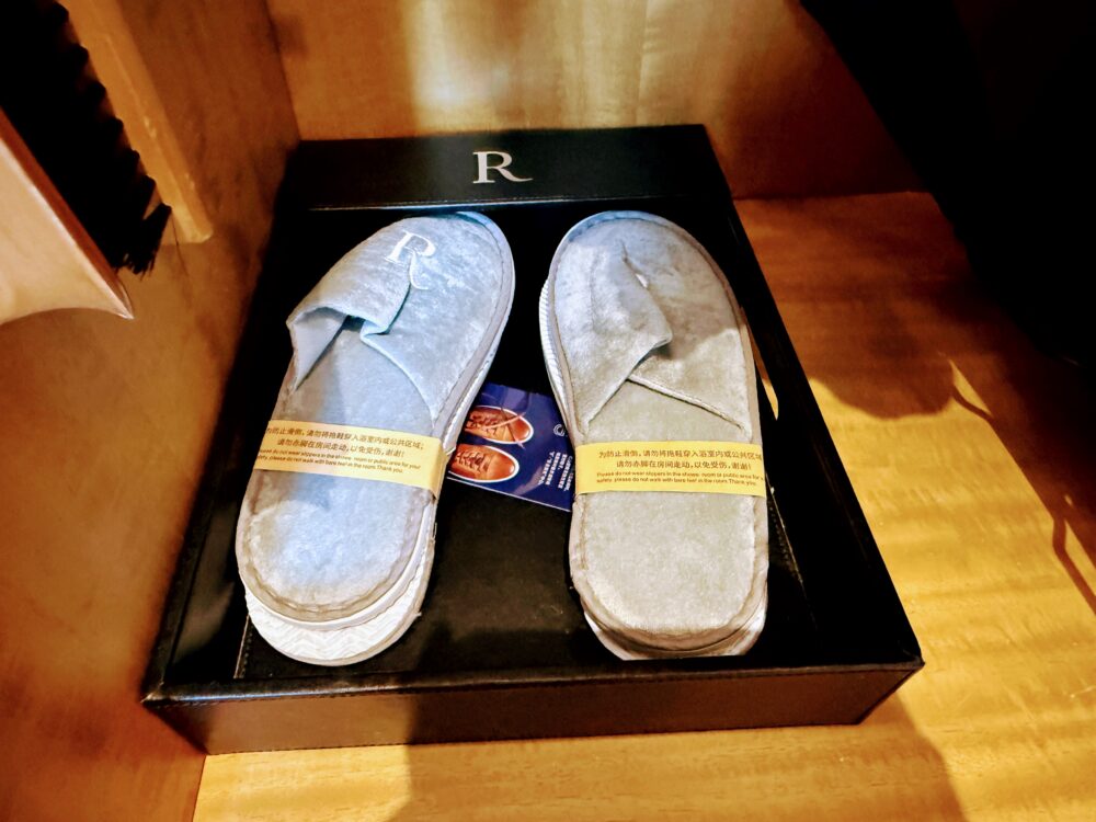 クローゼット内に用意されたグレーのルネッサンスロゴ入りスリッパ。ふかふかの素材で履き心地が良い。