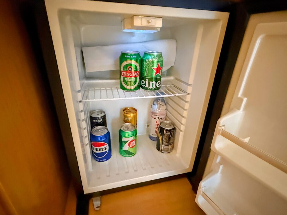 客室の冷蔵庫内。青島ビールやハイネケン、ソフトドリンクなどの有料ドリンクが入っている。