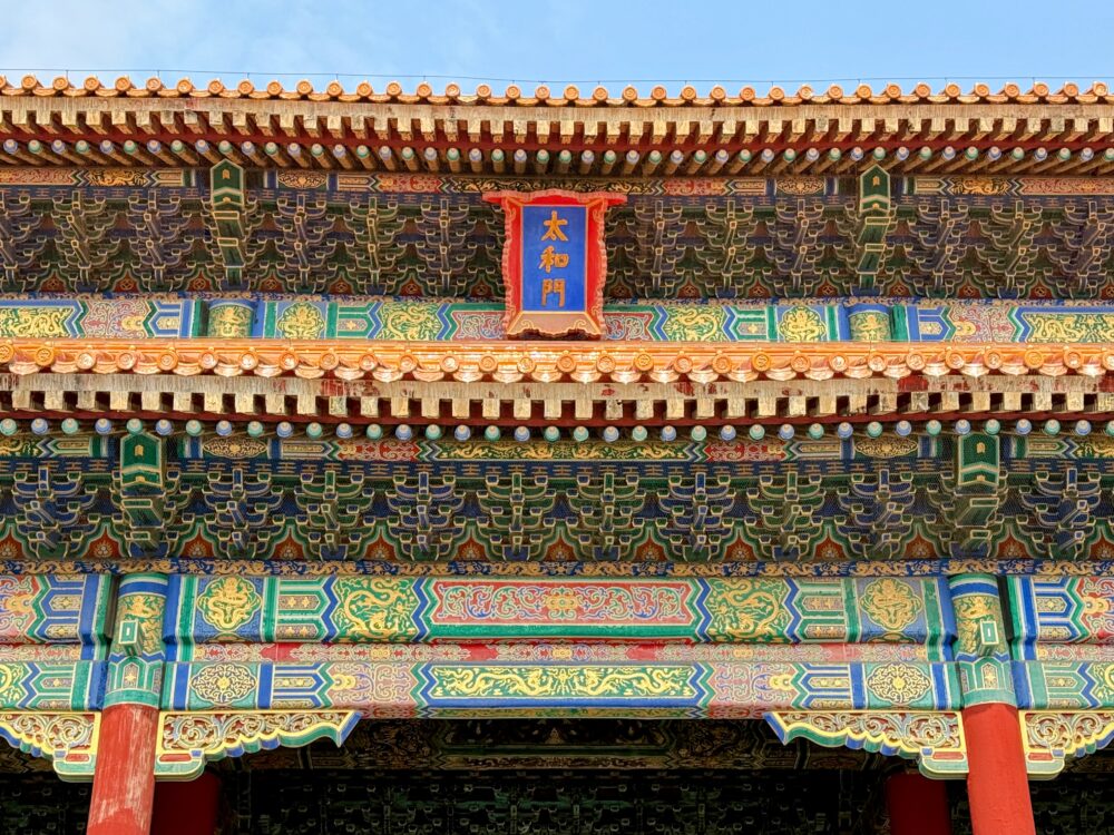太和門の装飾を近距離で撮影した写真。赤い柱の上に鮮やかな青・緑・金の文様がびっしりと描かれ、細やかな彩色と複雑な組み木模様が美しく表現されている。