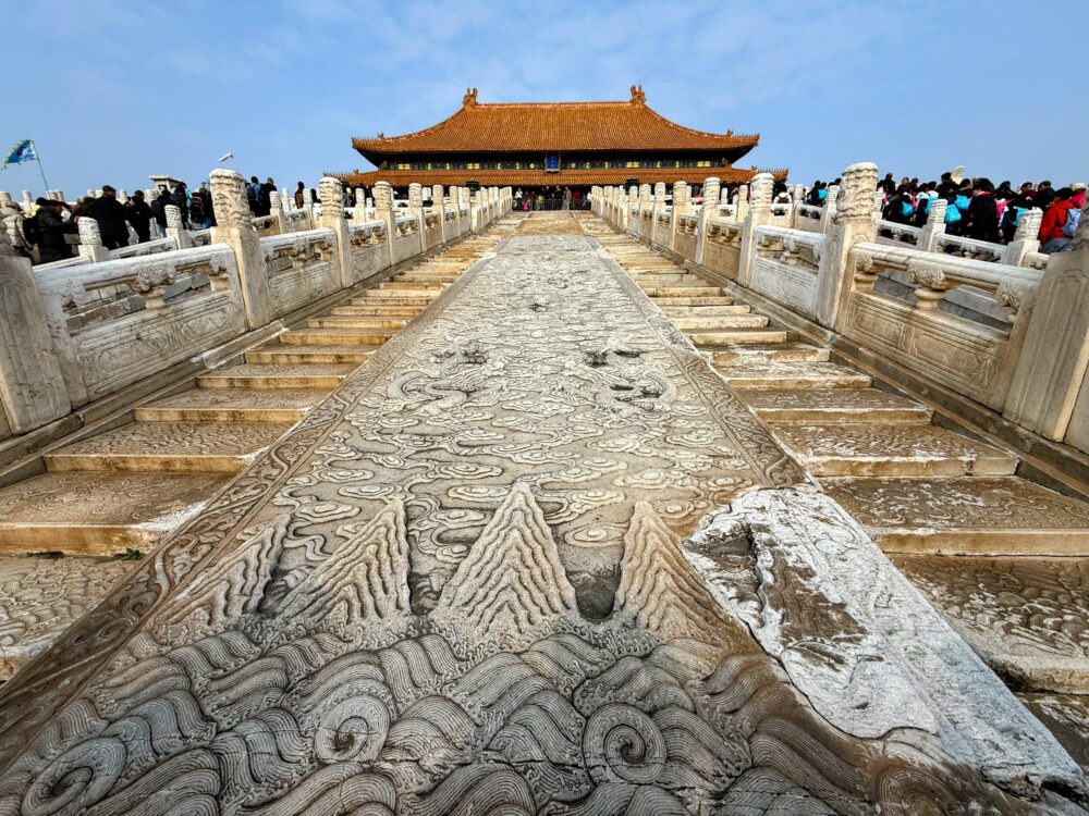 太和殿前にある長さ16mほどの巨大な龍のレリーフ。中央スロープを登る視点で、奥に太和殿がそびえる壮麗な景色。