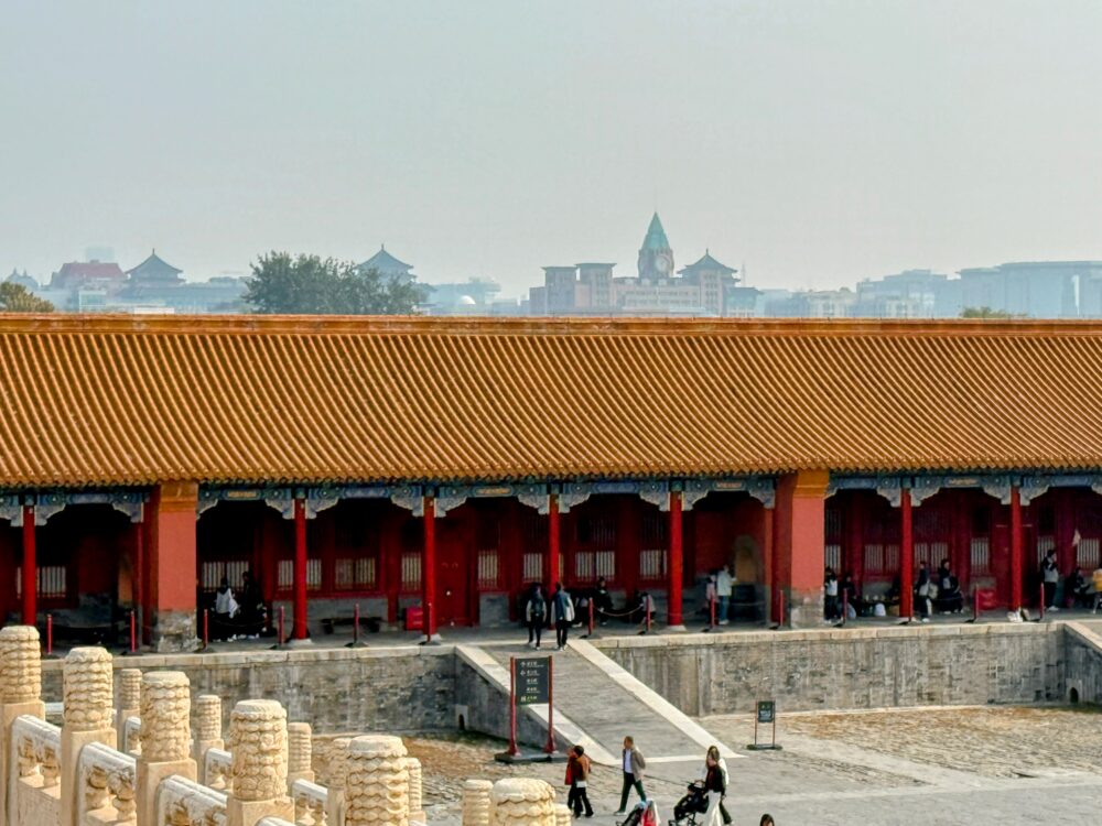 故宮・保和殿北側の回廊から望む北京の街並み。赤い宮殿の屋根越しに現代のビル群が見える風景。