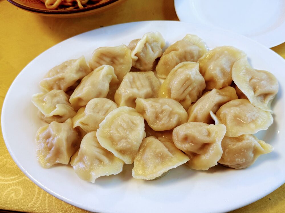 白い皿に盛られた20個の水餃子。ふっくらとした皮が並んでいる。