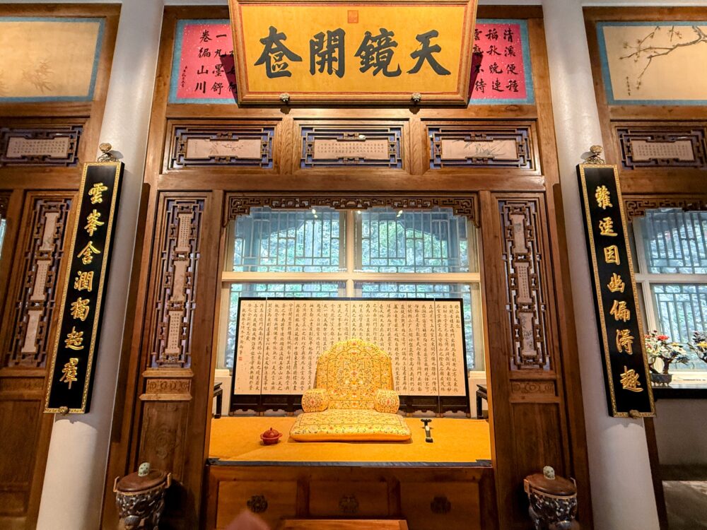 木彫りの枠に囲まれた空間に、金色のクッションが置かれた皇帝風の玉座が展示されている琼華島の内部。