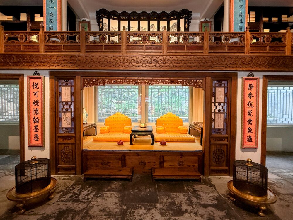 琼華島展示館の内部で、木枠に囲まれた伝統的な寝台と金色の座具が並ぶ展示エリア。