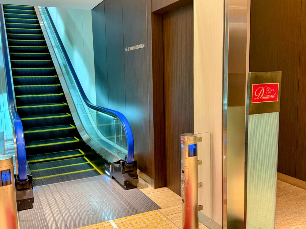 羽田空港国内線ANAスイートラウンジ専用入口のエスカレーター。ANAマイレージクラブ・ダイヤモンド会員専用の赤いサインが設置され、上階のラウンジへ直通できる特別な導線になっている。