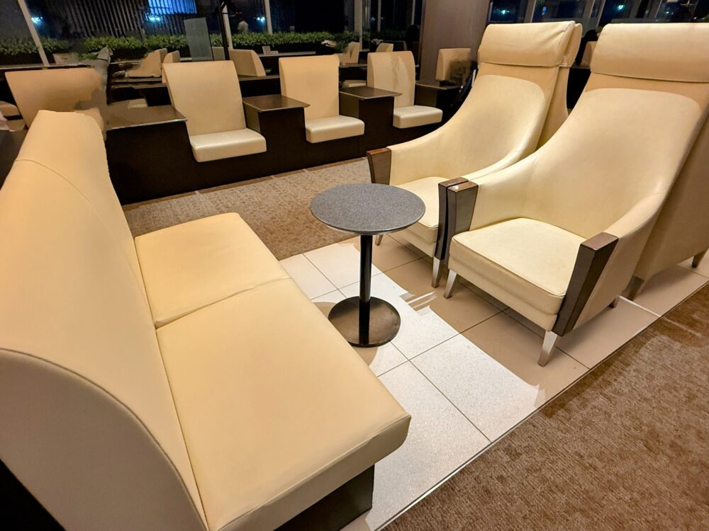 ANAスイートラウンジのソファ席エリア。2人掛けソファとハイバックチェアが向かい合うレイアウトで、落ち着いた雰囲気。