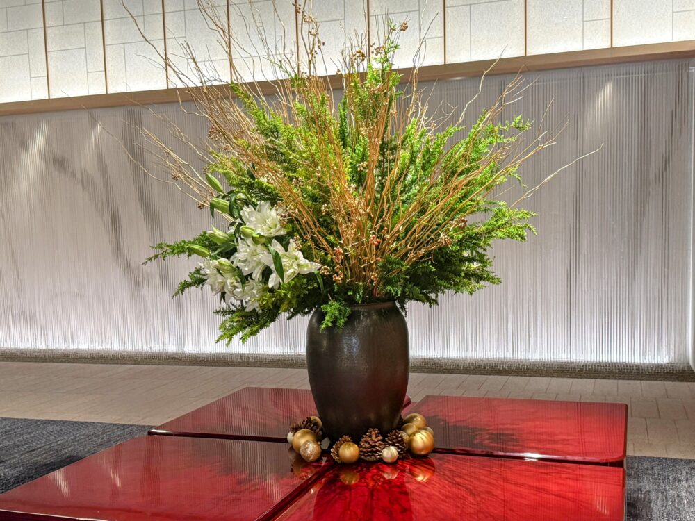 クリスマスオーナメントや松ぼっくりで飾られた華やかなフラワーアレンジメント