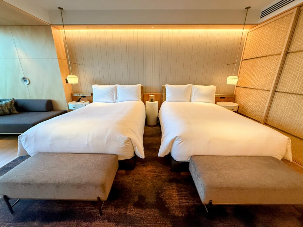 リッツカールトン福岡の客室のツインベッド。障子のようなデザインのヘッドボードと間接照明が落ち着いた雰囲気を演出している。