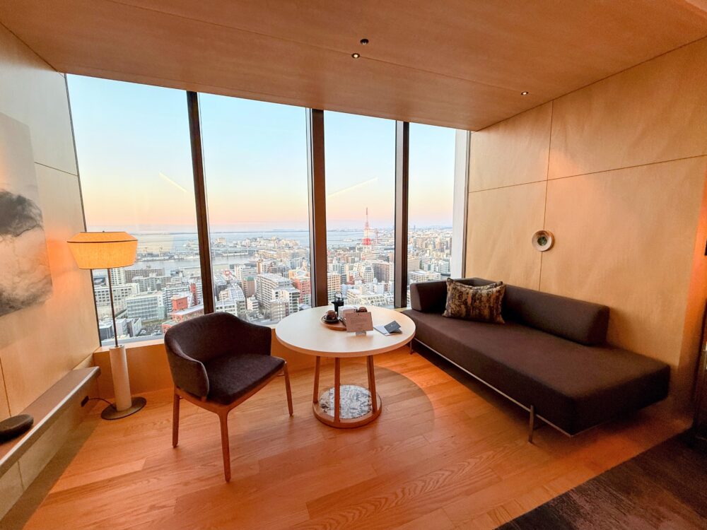 窓際に設置されたソファーと丸テーブル。窓の外には博多ポートタワーや福岡の街並みが見える