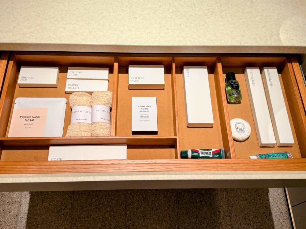 引き出しの中に綺麗に収納されたアメニティセット。MARVISの歯磨き粉や木製の箱に入ったブラシ、スキンケアセットなどが並んでいる