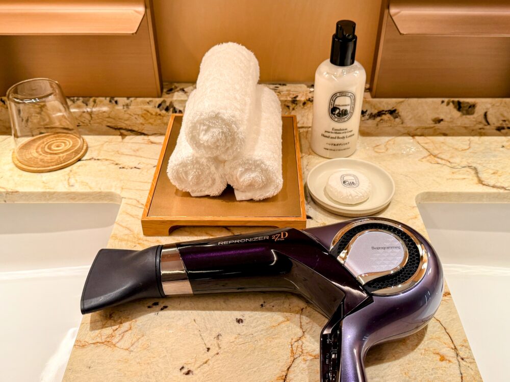 高級ドライヤー「レプロナイザー 27D Plus」と、Diptyqueのボディローション、石鹸、タオルが置かれた洗面台