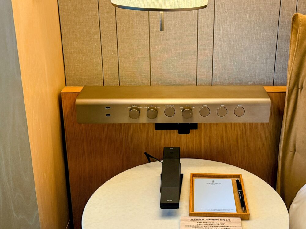 ベッドサイドのコントロールパネル。照明スイッチ、コンセント、USBポート（Type-A/C）が配置されている