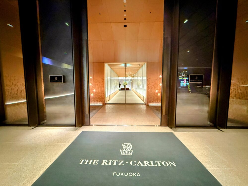 リッツ・カールトン福岡 1階エントランスのロゴ入りマットと、館内へと続く温かい光に包まれた通路