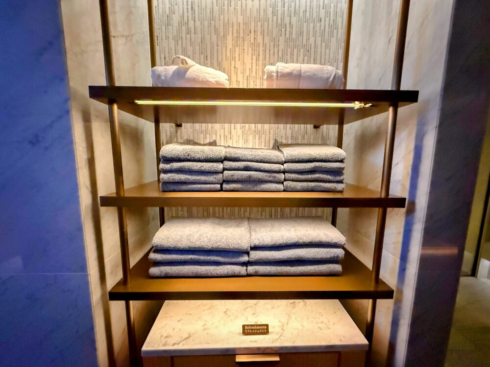 棚に美しく積まれたタオル類とバスローブ