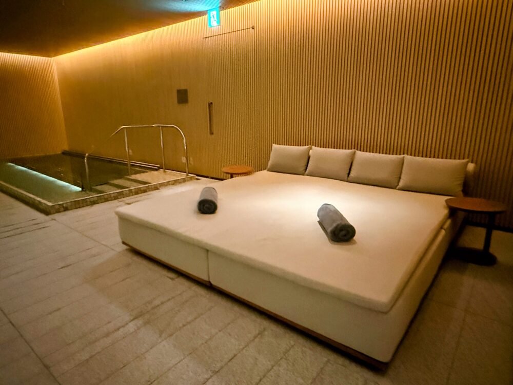 ジャグジーの隣にある、大人2人が余裕で寝そべられる大きな白いデイベッド