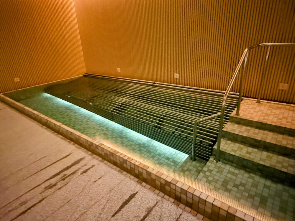 プールエリアにあるジャグジー。ステンレス製の寝湯スタイルで、泡が出ている