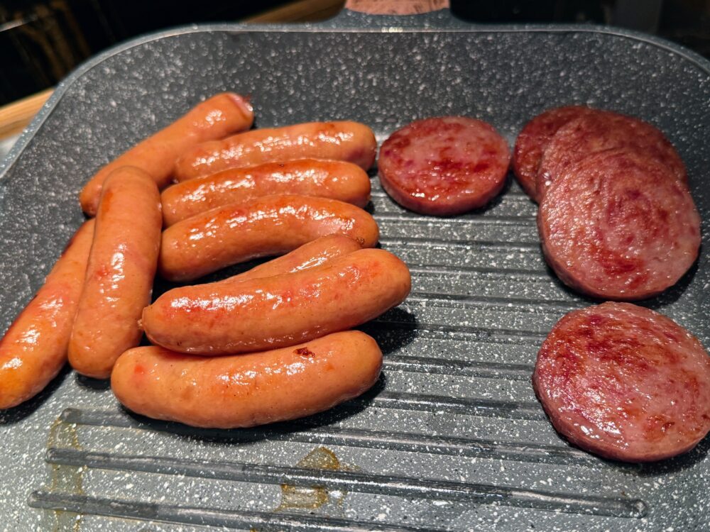 グリルされたジューシーなソーセージと厚切りのハムステーキ