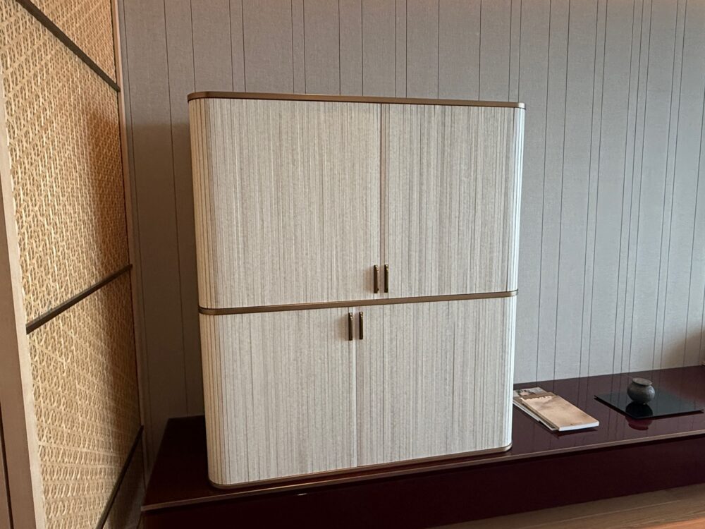 リッツ・カールトン福岡の客室にある、白い木目のスタイリッシュなミニバーキャビネット（閉じた状態）