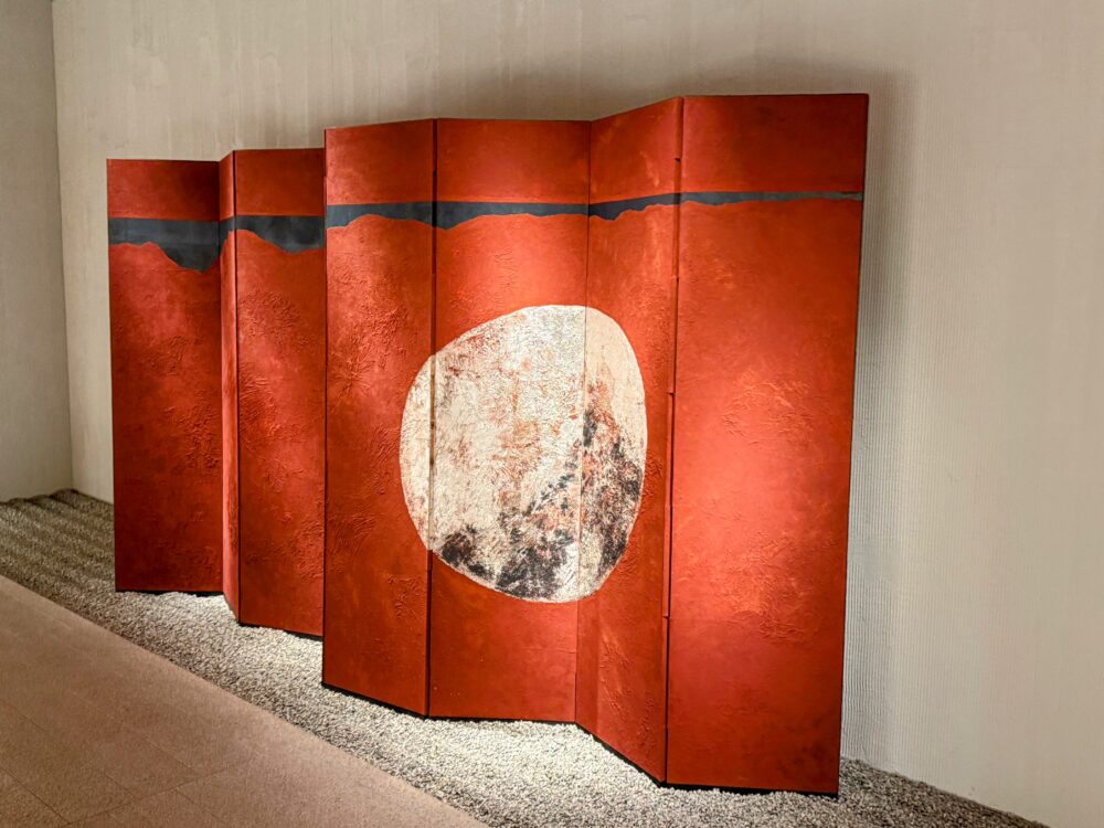 エレベーターホールに設置された、赤を基調に白い月が描かれた印象的な屏風アート