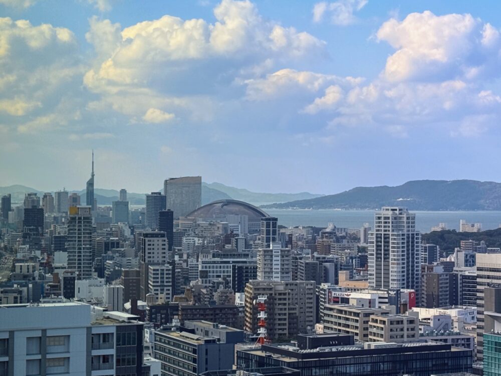 客室の左手方向に見える福岡のランドマーク。福岡タワーとPayPayドーム、そして海と山並みが広がる景色